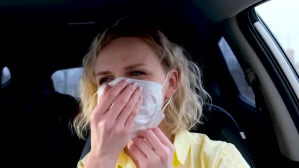 4k lockigt blond flicka förare sätta på medicinsk mask och skyddshandskar i bilen innan du kör. Kvinna i gult sommarslitage mot förkylning vanlig influensa. Stanna hemma karantän. — Stockvideo