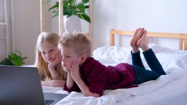 Distansutbildning på nätet. Schoolboy och flicka studerar hemma med digital surfplatta bärbar dator och göra skolan läxor. Sittande på sängen med träningsböcker. — Stockvideo