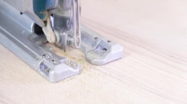 4 bin. Testereyle yakın plan çekimde çalışıyorum. Marangoz elektrikli testereyle odun kesiyor. Mutfakta elektrikli testereyle, kalın ahşap bir tezgahla daire şeklinde gördüm. uçan talaş.