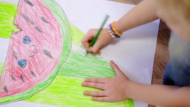 4 bin. Evdeki çocuklar. Küçük sarışın kızın elleri yere karpuz çizerek yaz resmi çiziyor. Karantinaya alın. Evde kal.