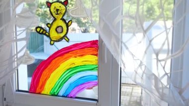 4 bin. Covid-19 karantinası sırasında pencereye gökkuşağı ve kedi çizen çocuklar. Evde kalıp koronavirüs önleme, hepimiz iyi olalım, umarım. Gökkuşağını kovala