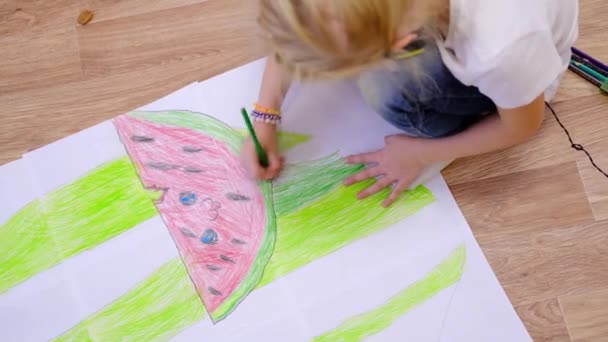 4k. Des enfants à la maison. Gros plan mains de petite fille blonde dessin image d'été avec pastèque sur le sol. En quarantaine. Reste à la maison — Video