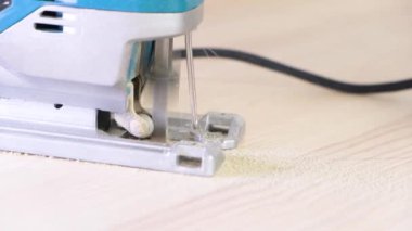 4 bin. Testereyle yakın plan çekimde çalışıyorum. Marangoz elektrikli testereyle odun kesiyor. Mutfakta elektrikli testereyle, kalın ahşap bir tezgahla daire şeklinde gördüm. uçan talaş.