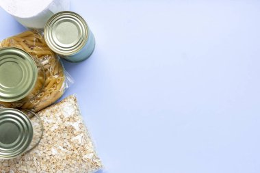 Gıda, mavi arka planda karantina süresi için gıda stoku sağlıyor. Pirinç, makarna, yulaf ezmesi, konserve yiyecek, şeker, tuvalet kağıdı. Yemek teslimatı, bağış, koronavirüs karantinası. Kopyalama alanı