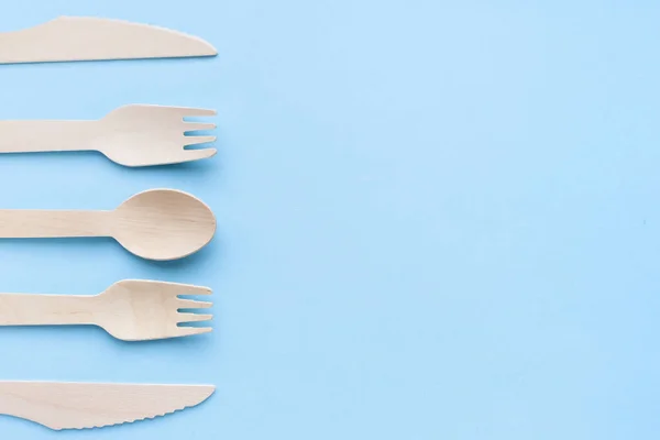 Eco friendly disposable kitchenware utensils on blue background. wooden forks and spoons. ecology, zero waste concept. top view. flat lay. copyspace — Stock Photo, Image