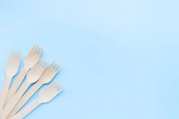 Eco friendly disposable kitchenware utensils on blue background. wooden forks and spoons. ecology, zero waste concept. top view. flat lay. copyspace — Stock Photo, Image