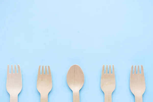 Eco friendly disposable kitchenware utensils on blue background. wooden forks and spoons. ecology, zero waste concept. top view. flat lay. copyspace — Stock Photo, Image