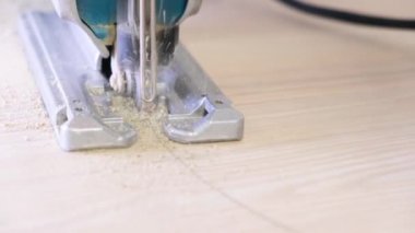 4 bin. Testereyle yakın plan çekimde çalışıyorum. Marangoz elektrikli testereyle odun kesiyor. Mutfakta elektrikli testereyle, kalın ahşap bir tezgahla daire şeklinde gördüm. uçan talaş.
