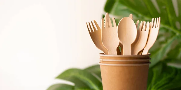 Bunner eco friendly disposable kitchenware utensils on white background. wooden forks and spoons in paper cup. and green leaf. ecology, zero waste concept. copyspace — Stock Photo, Image