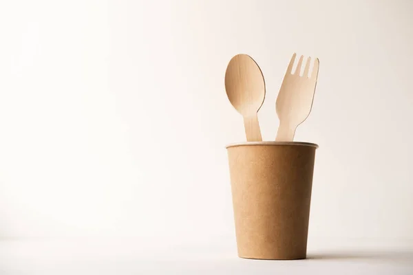 Eco friendly disposable kitchenware utensils on white background. wooden forks and spoons in paper cup. ecology, zero waste concept. copyspace — Stock Photo, Image