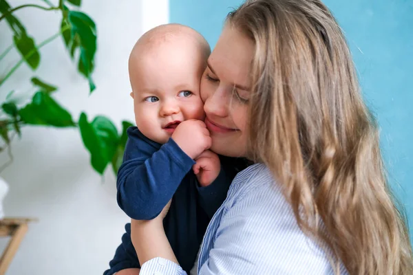 Feliz bebé. Poco más lindo gordito caucásico bebé blanco mirando y sonriendo a la cámara en las manos de la madre. La vida familiar, el amor de las madres, la maternidad — Foto de Stock