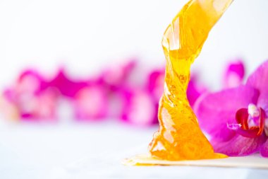 Tahta spatula çubuklarından akan tüyleri temizlemek için bal ya da şeker ezmesi. çiçek arkaplanı - tüy dökücü ve güzellik konsepti. kopyala