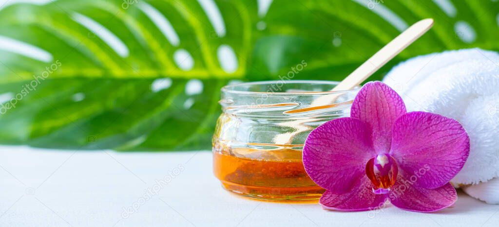 banner sugar paste or wax honey for hair removing with wooden waxing spatula sticks. flower background - depilation and beauty concept