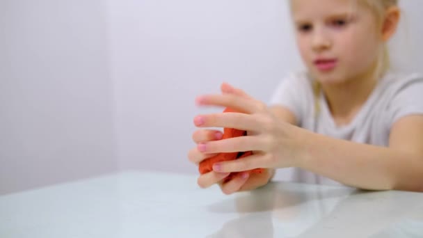 Blond meisje dat roze glitter slijm naar de zijkanten uitrekt. Kinderen spelen slijmspeeltje. Slijm maken. Kopieerruimte. Selectieve focus. — Stockvideo