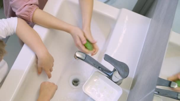 Kind wäscht sich im modernen Badezimmer die Hände mit grüner Seife. Reinigung, Hygiene und Prävention. 4k Filmmaterial — Stockvideo