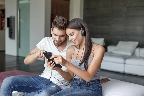 Young couple listening music on sofa