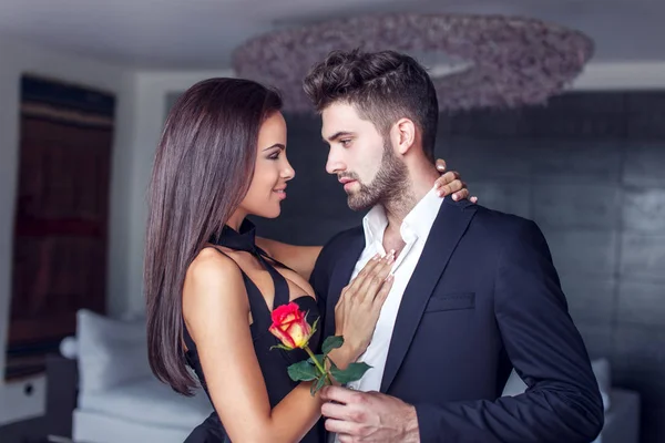 Молодий чоловік дарує троянду коханцеві в приміщенні — стокове фото