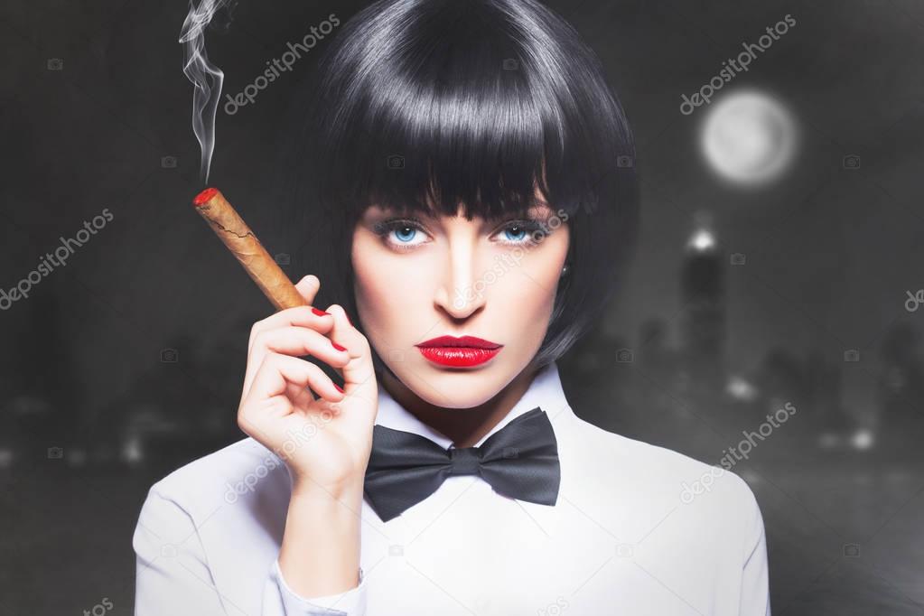 Sexy mafiosi woman boss in tux smoke with cigar