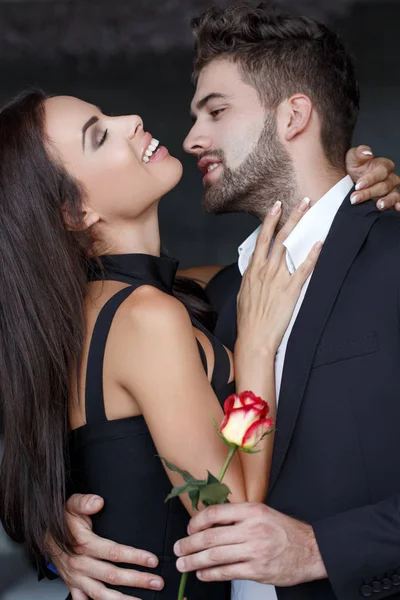 Ευτυχισμένο νεαρό ζευγάρι με τριαντάφυλλο — Φωτογραφία Αρχείου
