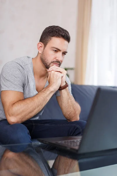 Young man watching laptop indoor