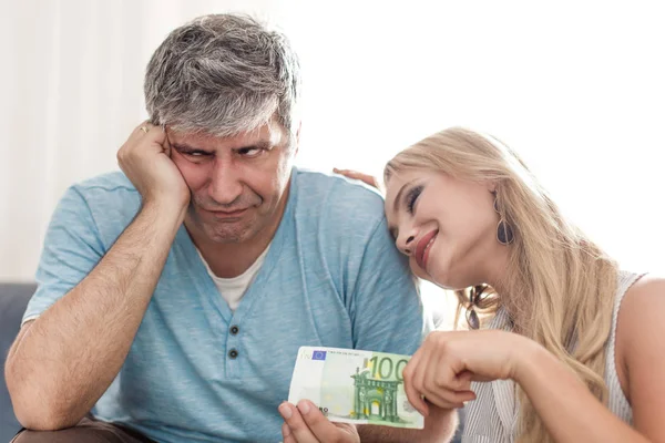 Triste marido dar 100 euros a la joven cazafortunas esposa — Foto de Stock