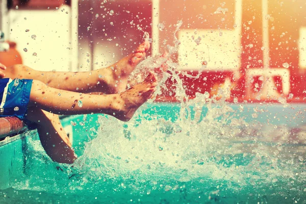 Niños piernas salpicaduras de agua en la piscina vintage — Foto de Stock