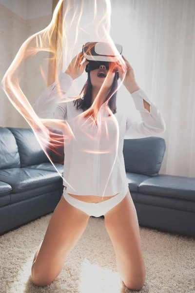 Seksikäs brunette nainen nauttii virtuaalitodellisuus kotona, tulinen danc — kuvapankkivalokuva