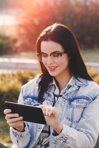 Chytrá mladá moderní žena v komunikaci pomocí tabletu venku — Stock fotografie