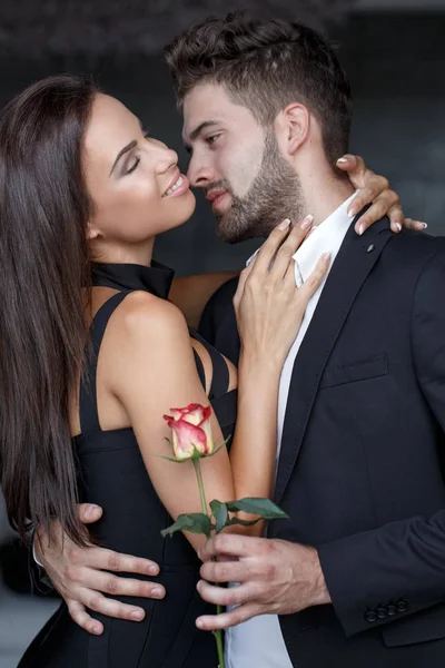 Νέος άνθρωπος Αγκαλιάζοντας γυναίκα και δίνουν τριαντάφυλλο — Φωτογραφία Αρχείου