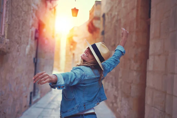 Donna felice che cammina sulla strada mediterranea al tramonto — Foto Stock