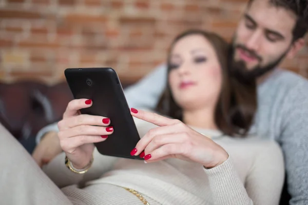 Casal jovem compras on-line por tablet em casa — Fotografia de Stock