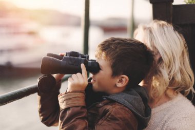 Dürbünle tarafından distantance izlerken mutlu beyaz çocuk
