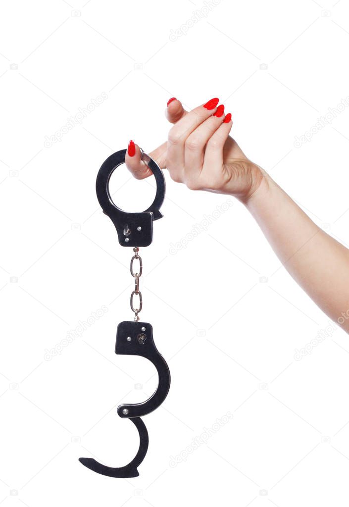 Woman hands with red nails holding handcuffs isolated