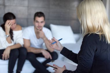 Blonde therapist discussing with couple on consulation clipart