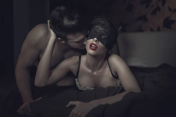 Сексуальна жінка в мереживному покритті для очей і червоні губи з молодим коханцем — стокове фото