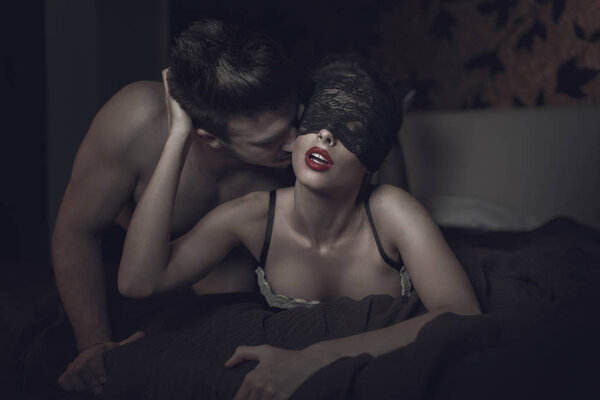 Sexy woman in lace eye cover and red lips with young lover