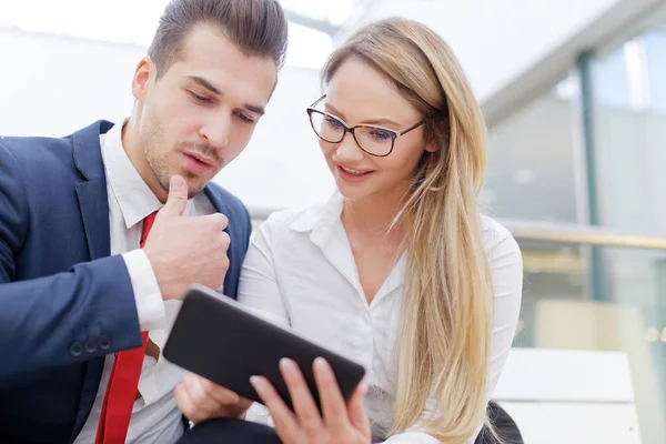 Junge kooperative Geschäftsleute nutzen Tablet im Business Center — Stockfoto