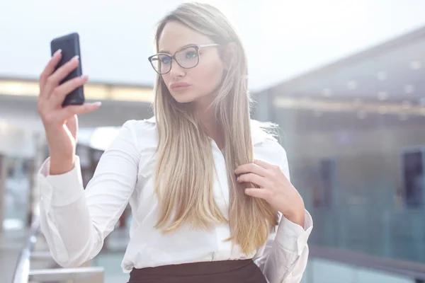 Joven mujer de negocios rubia inteligente en gafas tomando selfie en —  Fotos de Stock