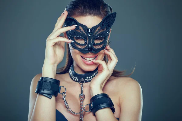 Mulher morena sexy brincalhão em máscara de mulher-gato e algema de couro — Fotografia de Stock