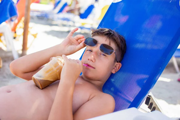 Liten pojke ta bort solglasögon medan du dricker frappe coffe av st — Stockfoto