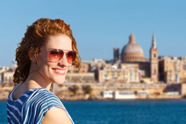 Happy young redhead woman tourist visiting Valletta, Malta clipart