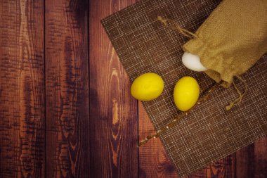 Beyaz ve sarı Paskalya yumurtaları ahşap bir masada bir torbada. üst yaşam