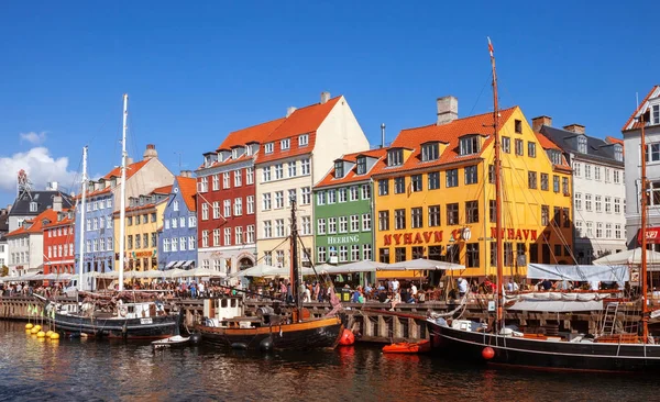 COPENHAGEN, DINAMARCA - 9 DE SEPTIEMBRE: personas en cafés abiertos del famoso paseo Nyhavn el 9 de septiembre de 2016 en Copenhague, Dinamarca. Nyhavn es uno de los monumentos más famosos de Copenhague . — Foto de Stock