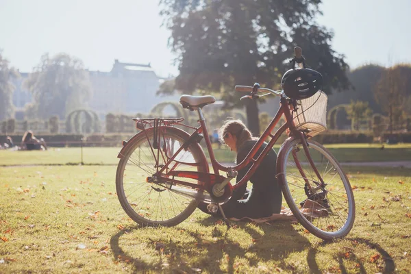 Menina com bicicleta lê um livro em Copenhague, Dinamarca — Fotografia de Stock