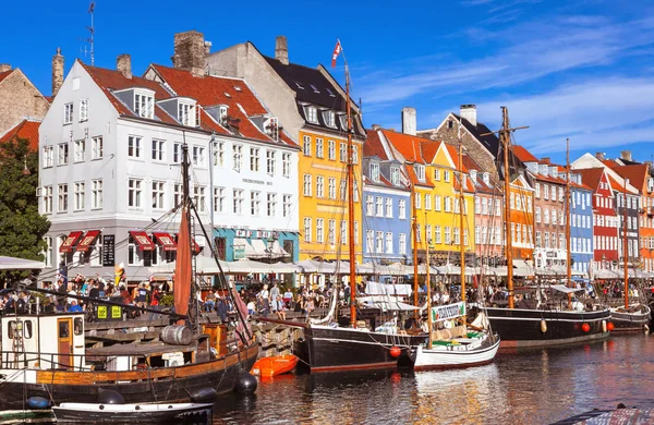 COPENHAGEN, DINAMARCA - 9 DE SEPTIEMBRE: personas en cafés abiertos del famoso paseo Nyhavn el 9 de septiembre de 2016 en Copenhague, Dinamarca. Nyhavn es uno de los monumentos más famosos de Copenhague . — Foto de Stock