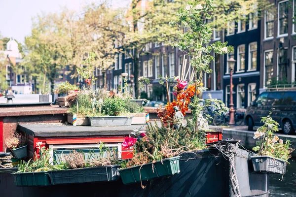 Симпатичные домики на амстердамских каналах со старой лодкой впереди — стоковое фото