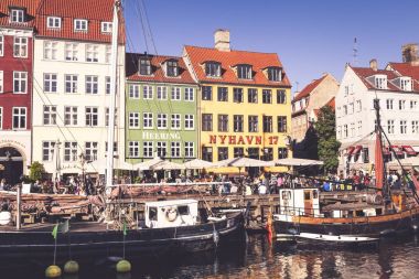 COPENHAGEN, DENMARK - SEPTEMBER 9: people in open cafes of the famous Nyhavn promenade on September 9, 2016 in Copenhagen, Denmark. Nyhavn is one of the most famous landmark of Copenhagen. clipart