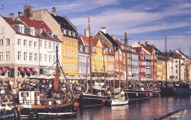 COPENHAGEN, DENMARK - SEPTEMBER 9: people in open cafes of the famous Nyhavn promenade on September 9, 2016 in Copenhagen, Denmark. Nyhavn is one of the most famous landmark of Copenhagen. clipart