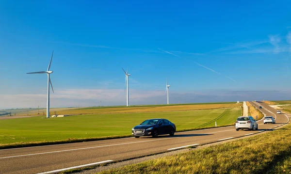 Automóviles en una autopista y aerogeneradores en el fondo - Francia — Foto de Stock