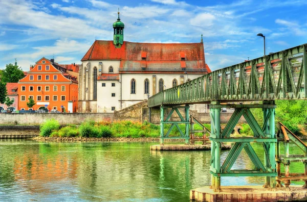 Iglesia de San Oswald con el puente Eiserner Steg sobre el río Danubio en Ratisbona, Alemania — Foto de Stock